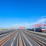 Infrastruktur transportasi modern dengan jalan, rel kereta, dan pelabuhan yang menunjukkan tugas sektor transportasi